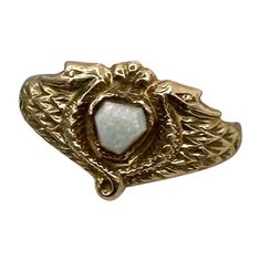 This is a museum quality antique Egyptian Revival Opal Snake Phoenix Bird Ring. The antique ring has a central hexagonal Opal cabochon of great beauty. The Opal is set in 10 Karat Gold. The opal is framed by two entwined snakes or stunning renditions of a winged Phoenix bird. The gold is a beautiful warm yellow 10 Karat Gold. It is very rare to find opals in the early antique Egyptian Revival jewels, and the combination with the snakes is extraordinary. The ring dates to circa 1860-1920. For centuries, Ancient Egypt has held the fascination of the public and continues to inspire artists and designers alike. With the discoveries of Egyptian tombs, and the treasures within, in the 19th and early 20th centuries, the exotically opulent lives of the Pharaohs were beyond anyone’s imagination. Of Egyptian Revival Jewelry, Bird Ring, Bird Rings, Phoenix Bird, Egyptian Revival, Warm Yellow, Antique Ring, Jewelry Accessories Ideas, Accessories Ideas