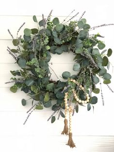 a wreath with greenery and beads hanging on the wall