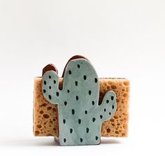 a small cactus figurine sitting on top of a piece of toasted bread