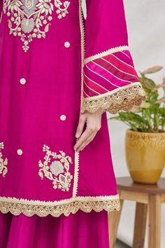 Magenta pink kurta with floral motif gota hand work and bell sleeves. Comes with gharara pants and scallop border dupatta.
Components:3
Embroidered
Neckline:Round
Sleeve Length:Full
Fabric:Silk
Color:Pink
Bell sleeves
Striped panels
Back keyhole
Elastic waistband
Scallop lace trim dupatta - Aza Fashions Gharara Pants, Pink Kurta, Scallop Border, Silk Kurta, Embroidered Neckline, Magenta Pink, Fabric Silk, Hand Work, Scalloped Lace