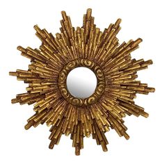 a gold sunburst mirror on a white wall