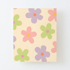 a small square paper with flowers painted on it's sides and the bottom half is pink, green, purple, and yellow