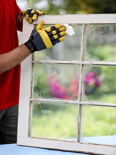 a person wearing gloves is cleaning a window