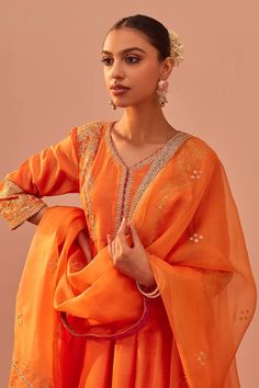 Tangerine orange peplum anarkali with tilla, patra, zari thread embroidery. Paired with gharara and geometric hand block print dupatta.
Components: 3
Pattern: Embroidery
Type Of Work: Tilla, patra, zari thread
Neckline: V neck
Sleeve Type: Three quarter
Fabric: Kurta: Silk Chanderi, Gharara: Georgette, Dupatta: Silk Organza
Color: Orange
Other Details: 
Tiered gharara
Gota lace embroidered hem
Sheer printed dupatta
Occasion: Sangeet - Aza Fashions Bollywood Designer Wear Sharara For Diwali, Bollywood Sharara With Pallu, Straight Kurta, Bollywood Style Sharara With Straight Kurta And Pallu, Bollywood Style Sharara With Zari Work For Diwali, Elegant Orange Sharara For Diwali, Traditional Orange Sharara With Sheer Dupatta, Traditional Orange Sharara With Dori Work, Orange Gota Work Salwar Kameez For Wedding, Orange Salwar Kameez With Gota Work For Wedding