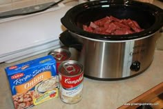 the crock pot is full of meat and seasoning next to some other ingredients