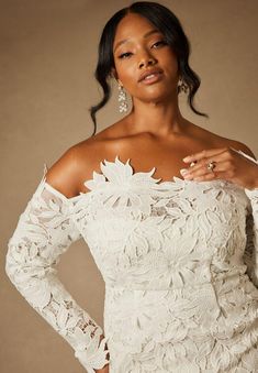 a woman in a white dress posing for the camera with her hands on her hips