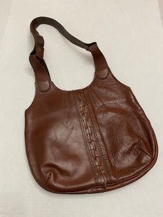 "Vintage leather shoulder bag, has a fun stitch up the center, pocket inside...very 70's boho! Maker/Brand: Don Quixote, New York, Made in Dominican Republic Year: 1970's Measurements: 12 1/4\" x 9 3/4\" plus another 11 1/2\" for strap Color: Brown, slightly red tinge Material: Leather, vinyl, metal Condition: Vintage, pre-owned All vintage is sold in \"as-is\" condition. We do our best to list any flaws. Purse is in good condition. Leather does have some crinkling to it on the front. Please see Vintage Everyday Hobo Bag Shaped As Satchel, Vintage Satchel Hobo Bag, Vintage Hobo Satchel Bag For Everyday, Vintage Everyday Hobo Bag, Vintage Satchel Hobo Bag For Everyday, Vintage Everyday Shoulder Bag With Pockets, Vintage Shoulder Bag For Daily Use With Pockets, Vintage Hobo Bag With Leather Backing For Travel, Vintage Leather-backed Hobo Satchel Bag