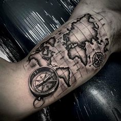 a man's arm with a map and compass tattoo on it