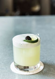 a margarita cocktail with an olive garnish on the rim