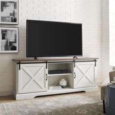 a flat screen tv sitting on top of a white entertainment center in a living room