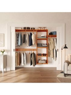 an open closet with clothes and shoes hanging on the shelves, next to a couch