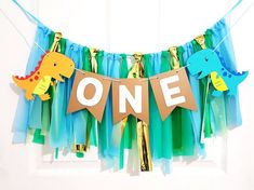 a one year old birthday banner with dinosaurs on it