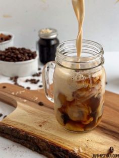 coffee being poured into a mason jar on a cutting board with chocolate chips in the background