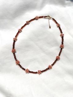 adorn yourself with the rich, chocolatey hues of the cocoa blossom necklace 🤎 ❥ bead assortment: mini brown glass crystals & acrylic flower beads  ❥ length: 16, 18 or 20 inches + extension chain with heart tag ❥ necklace findings: gold or silver plated stainless steel & tarnish resistant ⊹ ₊  ₊ ⊹⊹ ₊  ₊ ⊹⊹ ₊   ʚ♡⃛ɞ jewelry care tips ʚ♡⃛ɞ ❥ don't leave your beaded jewelry sitting in the sun ❥ avoid excessive stretching or pulling on your necklace ა heavenly made in NC ໒꒱ Brown Tiny Beads Necklace For Gift, Brown Flower-shaped Beaded Jewelry, Brown Beaded Necklace With Faceted Beads For Gifts, Brown Faceted Beads Necklace As Gift, Brown Faceted Beads Necklace For Gift, Accessories Minimalist, Brown Necklace, Boho Choker, Acrylic Flowers