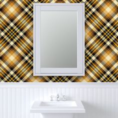 a bathroom sink sitting under a mirror next to a wall mounted faucet in front of a tiled wall