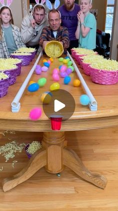 a group of people standing around a table with cakes and candy in front of them