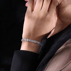 a woman wearing a diamond bracelet on her wrist