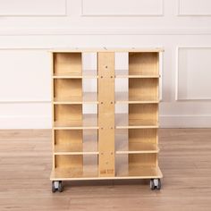 a wooden bookcase sitting on top of a hard wood floor next to a white wall