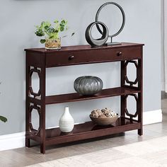 a wooden shelf with two vases on top of it and a mirror above it