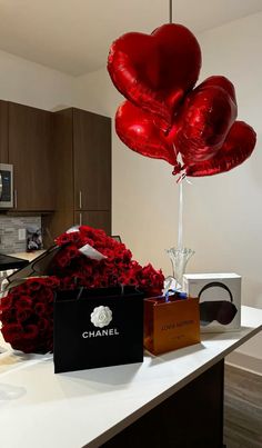 a bunch of red heart balloons sitting on top of a counter