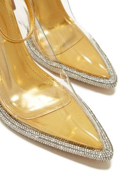 The Angelina - Gold Metallic Rhinestone Clear Pumps will make an elegant statement. These pumps feature a stunning combination of metallic, rhinestone, and clear accents, adding a luxe touch to any ensemble. Get ready to make a lasting impression each time you wear them. Stock Unit: 9B1 SIZE & FIT Heel Height Appro Clear Heels With Rhinestones For Prom, Chic Crystal Heels For Wedding, Gold Pointed Toe Heels With Bling, Glamorous Gold Heels With Rhinestones, Glamorous Sparkling Clear Heels, Chic Crystal Heels For Formal Occasions, Chic Crystal Heels With Rhinestones, Bedazzled Gold Heels For Party, Gold Bedazzled Heels For Party