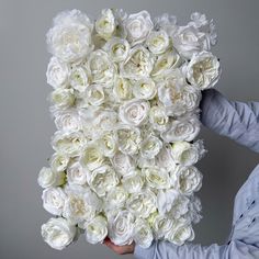 a person holding a bouquet of white roses