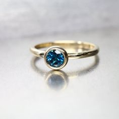 This minimalistic engagement ring features a london blue topaz. A simple yellow gold setting with a cup shaped bezel cradles this intense colored gemstone. This is a simple yet stunning bridal setting that can be worn with any wedding band.Created from 14k yellow gold in my studio. The 5mm cerulean blue topaz (treated) weighs 0.67ct.Ring Width: 1.8mmRing Thickness: 1.5mmShown in size 7 **Made to order in your size (please allow 1-2 weeks)nangijalajewelry.etsy.com*For your own protection and in o Color Wedding Band, Colored Wedding Bands, London Blue Topaz Engagement Ring, London Blue Topaz Engagement Rings, Blue Topaz Engagement Ring, Minimalist Engagement Ring, Topaz Engagement Ring, Yellow Gold Setting, London Blue Topaz