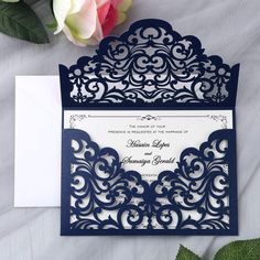 a wedding card with an intricate laser cut design on the front, and a flower in the back