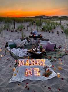 a beach scene with candles and decorations on the sand at sunset, including a sign that says happy new year