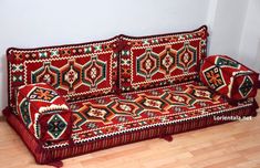 a red couch sitting on top of a hard wood floor