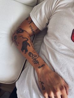 a man with tattoos on his arm laying down