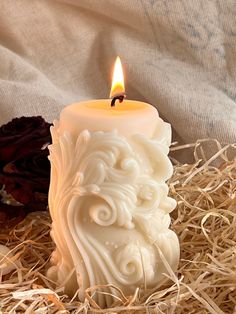 a candle that is sitting in some hay