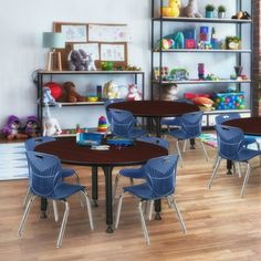 there are many children's tables and chairs in this room with toys on the shelves