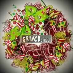 a christmas wreath with green and red candy canes on the front, and a sign that reads grin street