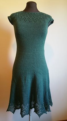 a green dress on a mannequin stand