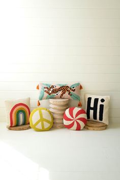 decorative pillows and pillow covers are arranged on a white surface in front of a wall