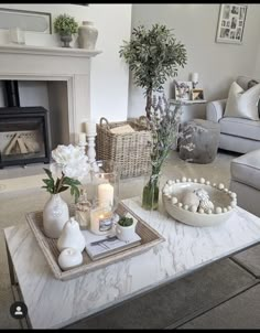 a living room filled with furniture and a fire place next to a table topped with flowers