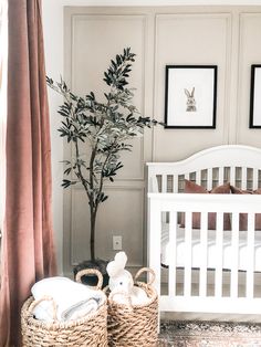 a white crib with two baskets and a baby's bed in the background