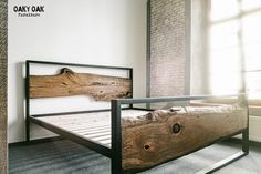 a bed frame made out of wood and metal in a room with brick wall behind it