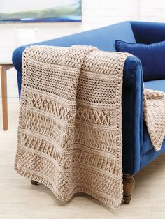 a crocheted blanket draped over a blue couch