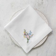 a white plate topped with a napkin covered in flowers