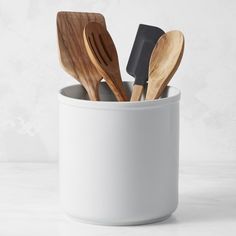 wooden spoons and spatulas in a white cup