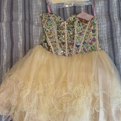 a dress with sequins on it and a purse hanging from the back, sitting on a bed