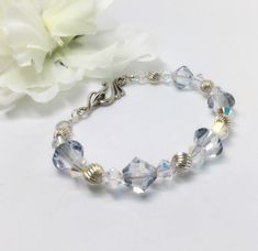 Swarovski Crystal Bracelet, Beaded Bracelet, Sterling Silver Bracelet, Iridescent Bracelet, Bridal Jewelry, Pale Blue Crystal Bracelet  This is a really beautiful bracelet.  Great gift for your BFF!  Or maybe something new for yourself.  Beautiful pale blue bicone shaped Swarovski crystals are the focal point of this bracelet. The large icy blue crystals, sterling silver beads and clear iridescent crystals make for very clean lines. Finished with a beautiful hook and loop clasp.  Bright and beautiful!   Beads are 6 and 8 mm.   Fits nicely around a 6 1/2 to 7 inch wrist. If you like this one, you might also like this: https://etsy.me/2Cqj4Bb Blue Crystal Bracelet, Iridescent Crystal, Swarovski Crystal Bracelet, Jewelry Blue, Icy Blue, Bracelet Beaded, Rose Gold Bracelet, Bead Jewellery, Crystal Bracelet