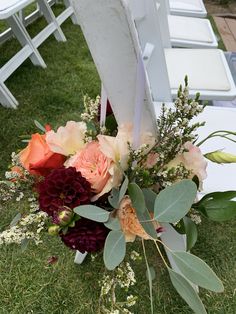 a bouquet of flowers sitting on top of a white chair next to an empty chair