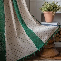 a potted plant sitting on top of a wooden table next to a white and green blanket