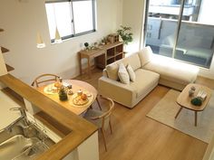 a living room filled with furniture next to a kitchen and dining room table in front of a window