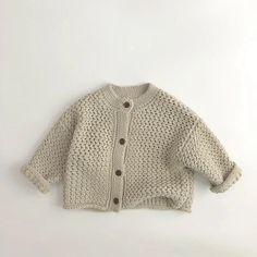 Get cozy this winter with our Button Down Knit Cardigan! Made from high-quality cotton, this casual cardigan is perfect for children aged 7 months to 6 years. Its o-neck collar and solid pattern add a touch of style, while the long sleeves provide warmth during the colder months. The heavy thickness ensures ultimate comfort, and the regular length makes it versatile for any occasion. Crafted with unisex design in mind, this cardigan fits true to size. Embrace the chilly season in style with our Cream Cotton Cardigan With Buttons, Beige Cotton Sweater With Buttons, Knitted Cotton Button-up Cardigan, Button-up Knitted Cotton Cardigan, Cute Knit Cardigan With Buttons, Cute Button-up Winter Sweater, Cute Button-up Sweater For Winter, Cute Cotton Cardigan With Button Closure, Cotton Cardigan With Button Closure, Cute Style