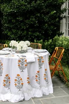 the table is set with white and orange linens for an outdoor dinner party or celebration