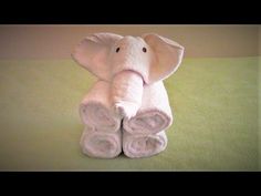 an elephant made out of towels sitting on top of a bed